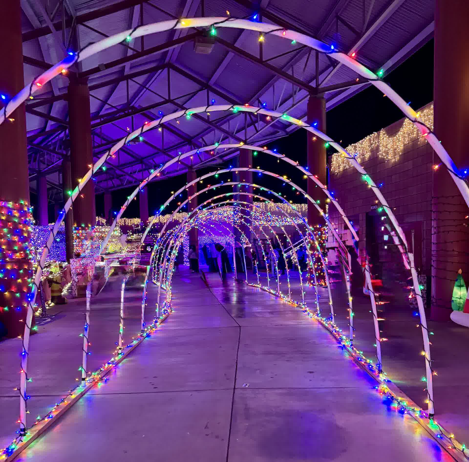 Families walking through a tunnel of colored lights